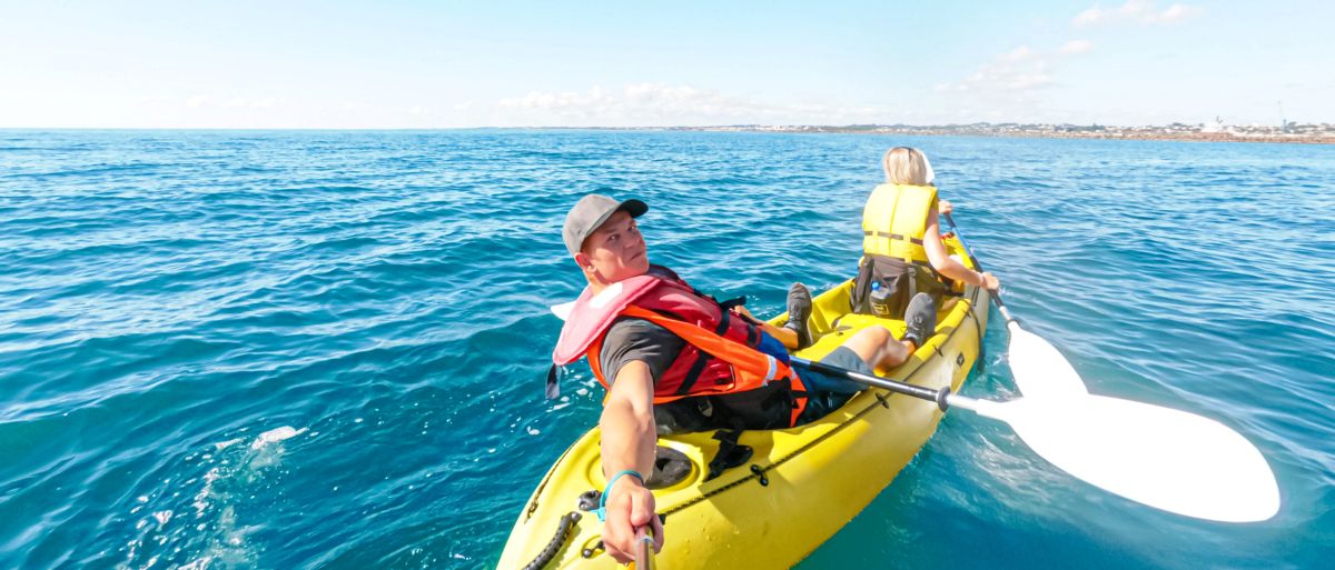 Sabina and Liam sea kayaking off the coast of New Plymouth toward Sugar Loaf Island, North Island, New Zealand