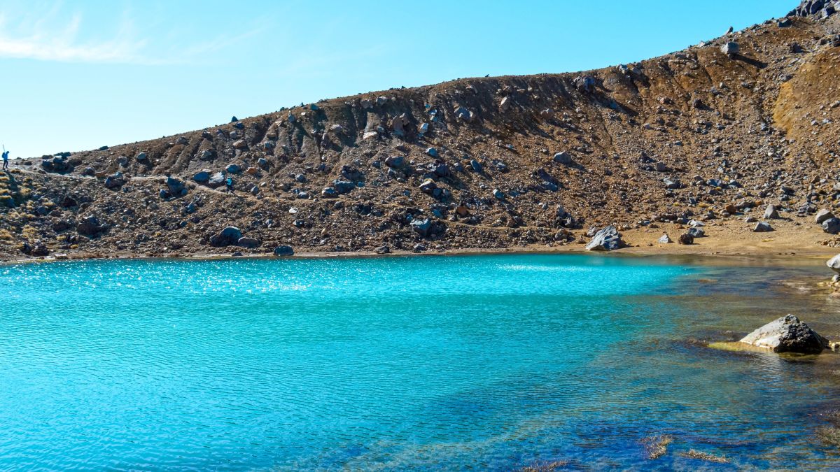 Sparkiling sufrace of Big Blue Lake surronded by volcanic rock, Tongariro National Park, North Island, New Zealand