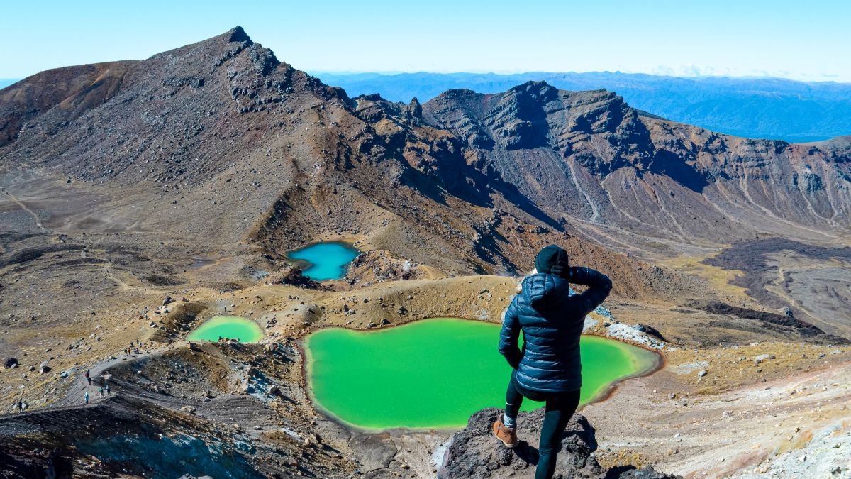 Sabina looking out towards the rugged volcanic landscape and blue and green Emerald Lakes in Tongariro National Park, North Island, New Zealand